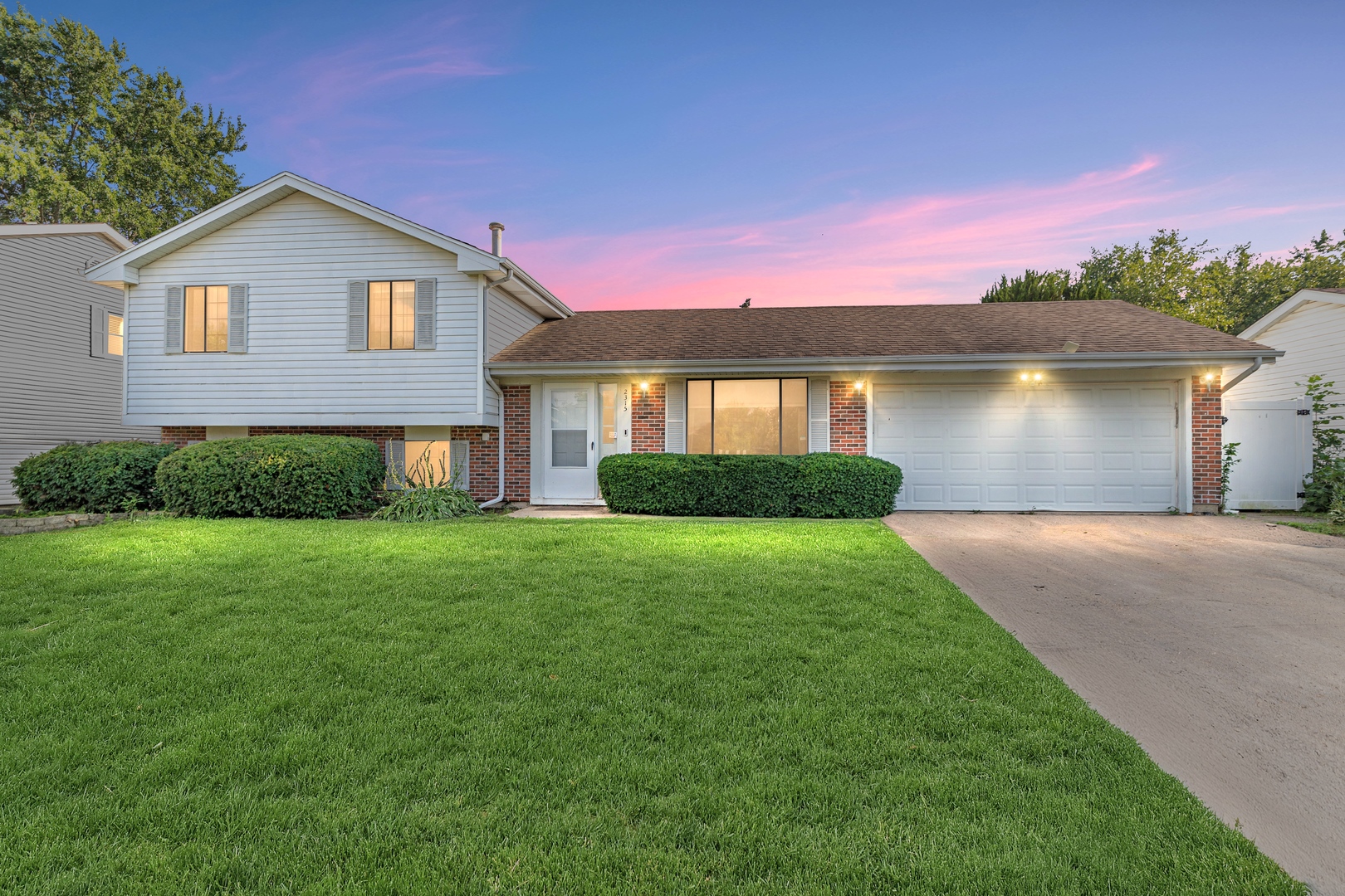 a front view of a house with a yard and lake view