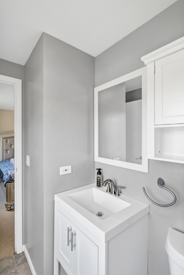 2315 Stepstone Lane Hanover Park, IL 60133 - Photo 16 of 30 a bathroom with a sink a toilet and a mirror