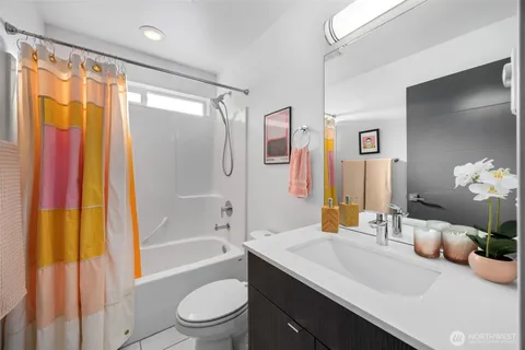 a bathroom with a granite countertop sink toilet and shower