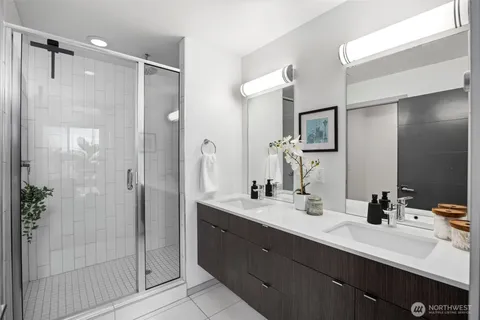 a bathroom with a double vanity sink mirror and shower