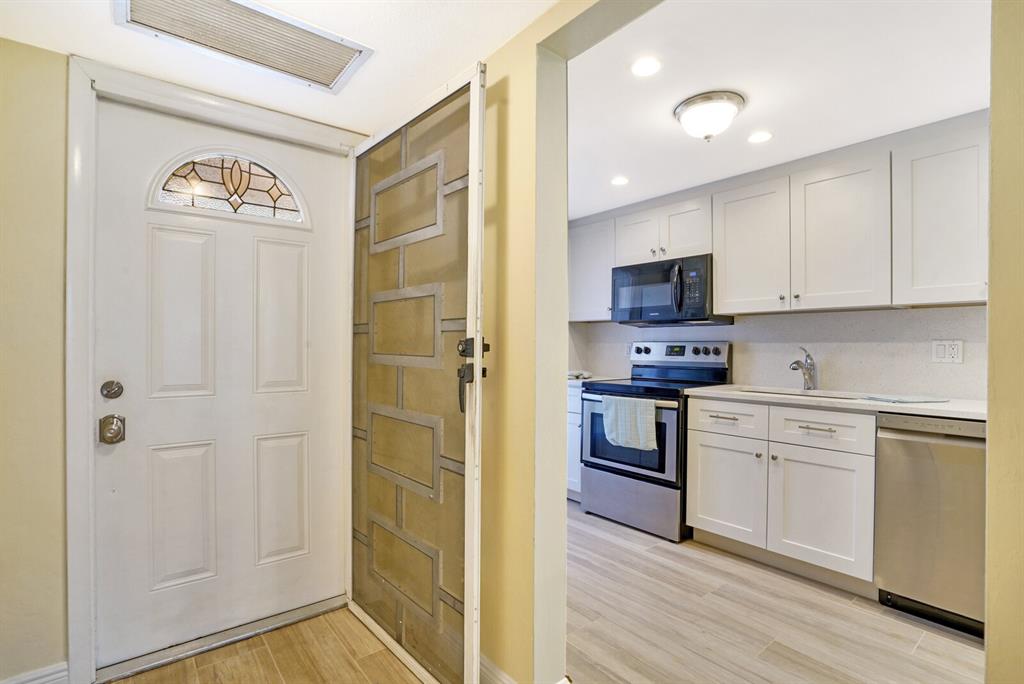 a kitchen with a refrigerator a stove top oven and cabinets