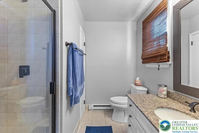 a bathroom with a granite countertop sink a toilet and shower curtain