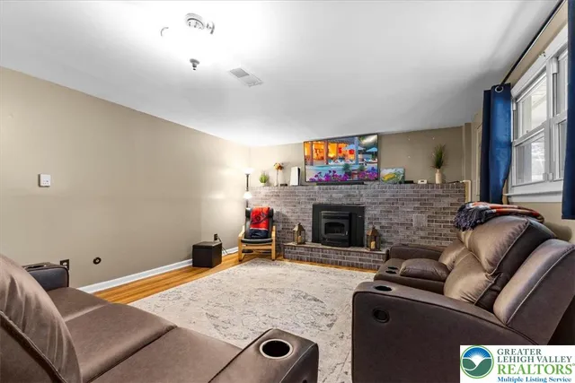 a living room with furniture a fireplace and a flat screen tv