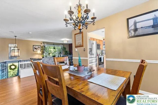 a view of a dining room with furniture a chandelier and wooden floor