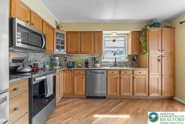 a kitchen with stainless steel appliances granite countertop a stove a sink and a refrigerator