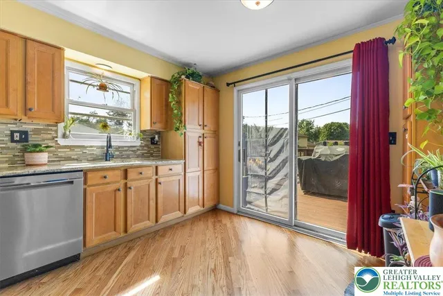 a kitchen with stainless steel appliances granite countertop a stove a sink and a large window