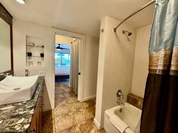 a bathroom with a sink and mirror with bathtub
