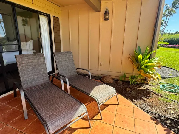 a view of a balcony with chairs and a potted plant