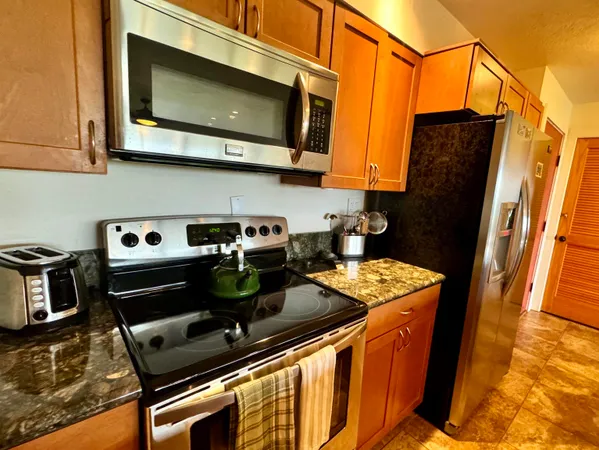 a kitchen with stainless steel appliances granite countertop a stove and a microwave
