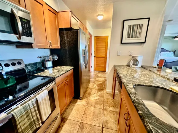 a kitchen with stainless steel appliances granite countertop a stove a sink and a microwave