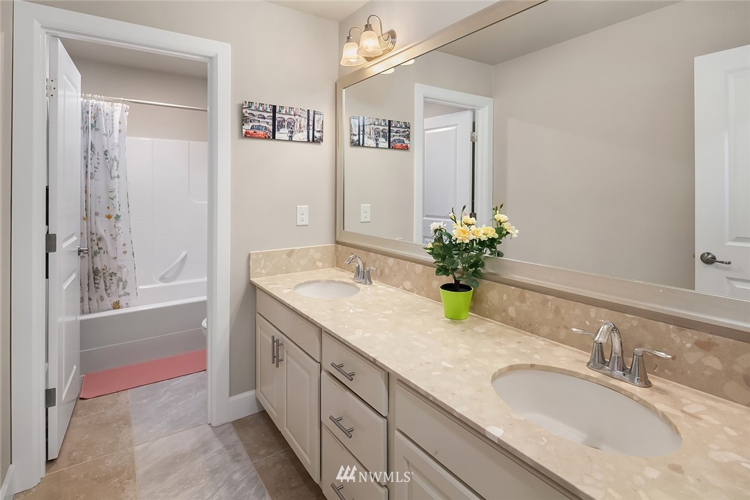 3911 174th Place Southeast Bothell, WA 98012 - Photo 22 of 27 a bathroom with a granite countertop sink and a mirror