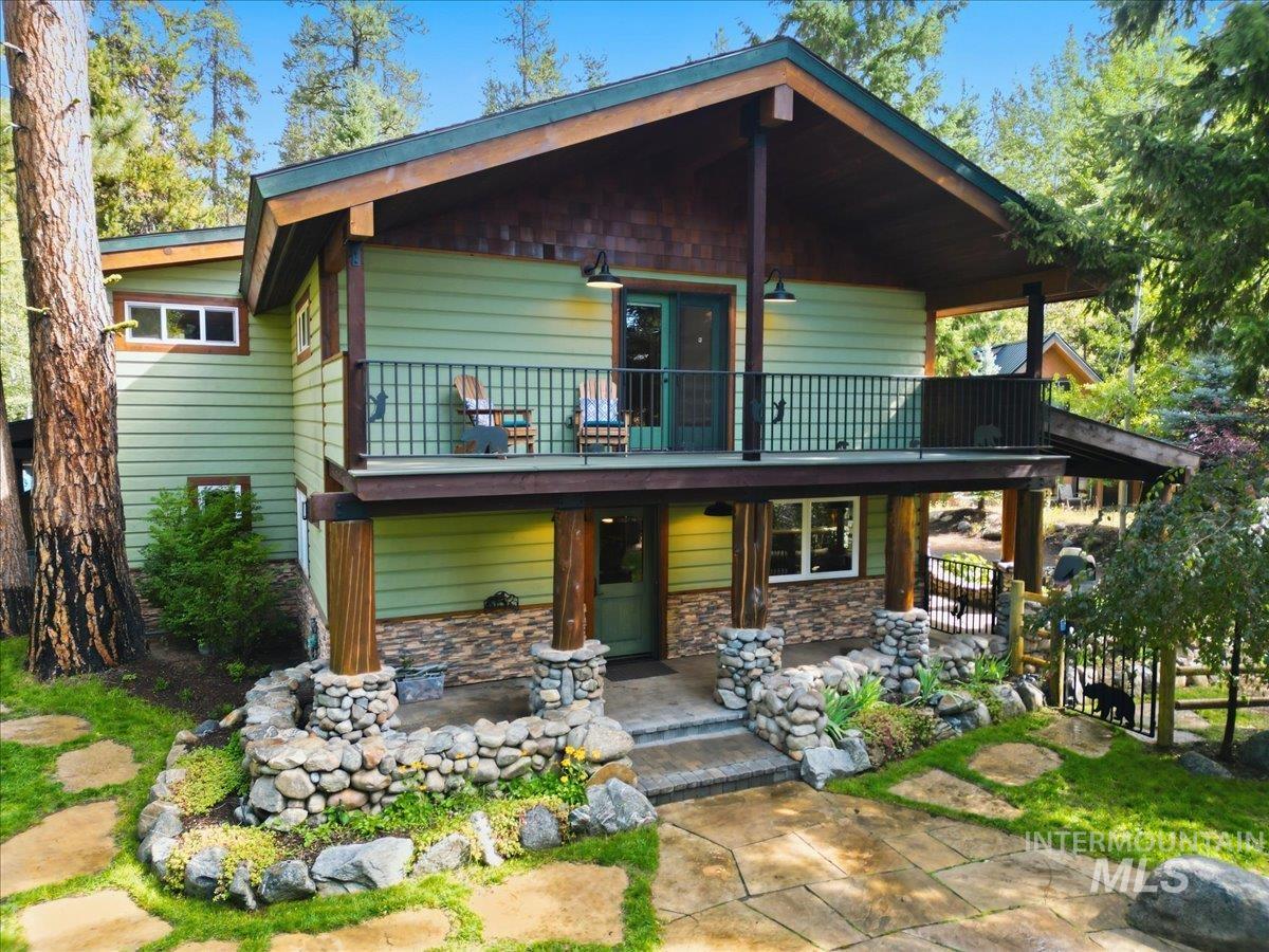 1029 Cee Way Loop McCall, ID 83638 - Photo 46 of 50 Wood-sided exterior with stone accents, covered front porch, and surrounding mature evergreen trees