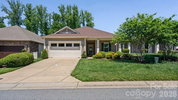 a front view of a house with a yard and potted plants