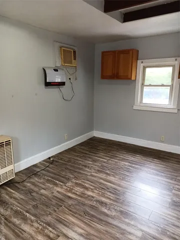 a view of a room with wooden floor and cabinet