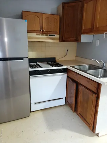 a kitchen with stainless steel appliances granite countertop a stove a sink and a refrigerator