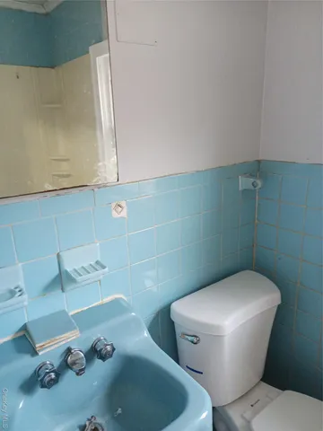a white toilet sitting next to a bathroom sink