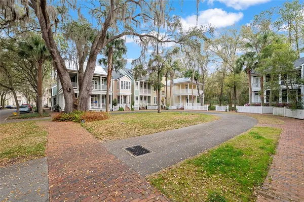 a view of residential houses with yard and trees