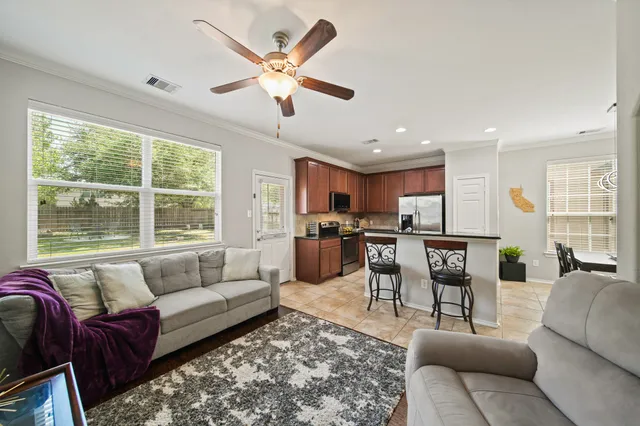 a living room with furniture kitchen view and a chandelier