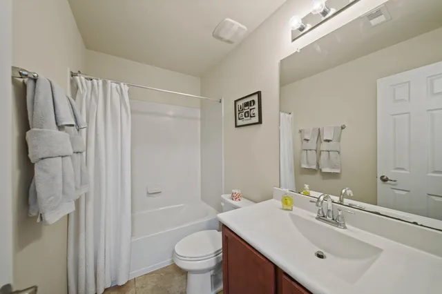 a bedroom with a bed and a chandelier fan