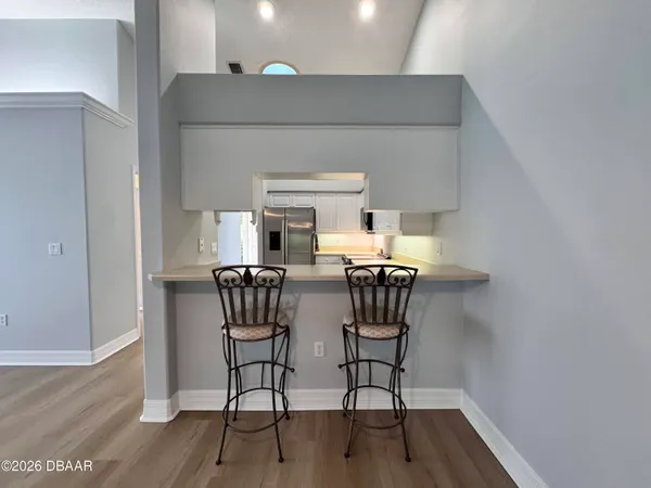 an empty room with wooden floor cabinet and a ceiling fan