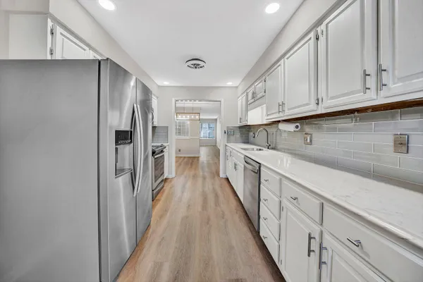 a kitchen with cabinets a sink and wooden floor