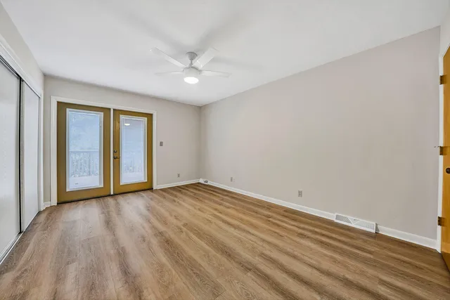 a view of an empty room with wooden floor
