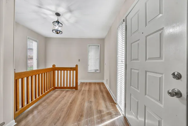 a view of a hallway with wooden floor and windows