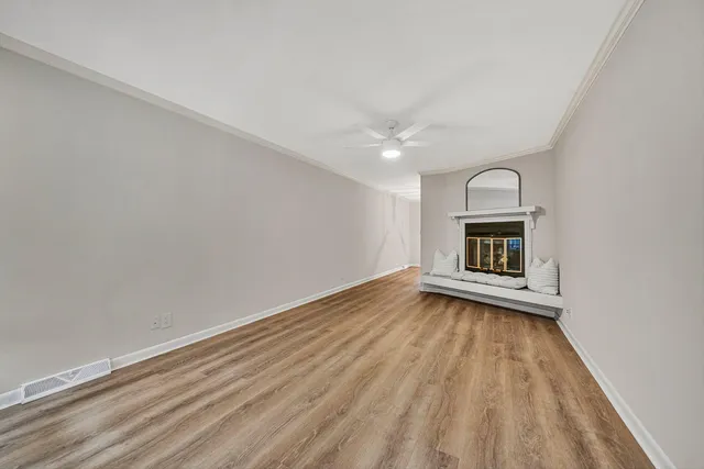a view of empty room with wooden floor and fireplace