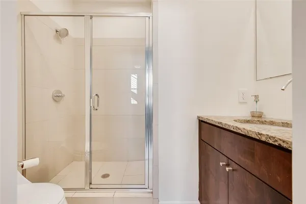 a bathroom with a granite countertop sink a toilet and mirror