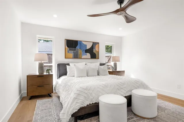 a spacious bedroom with bed and a wooden floor