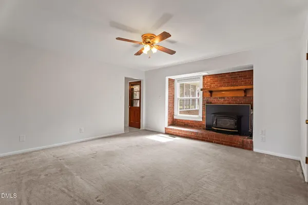 a view of empty room with fireplace and fan