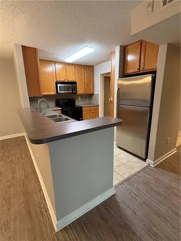 a kitchen with kitchen island a counter top space wooden floor and stainless steel appliances