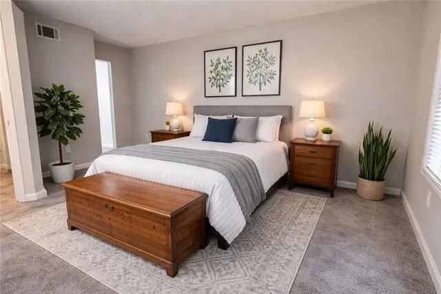 a spacious bedroom with a bed and a potted plant