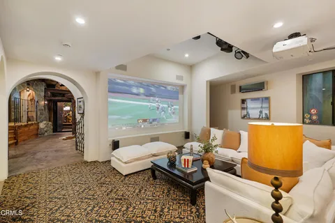 a living room with large couches and kitchen view with wooden floor
