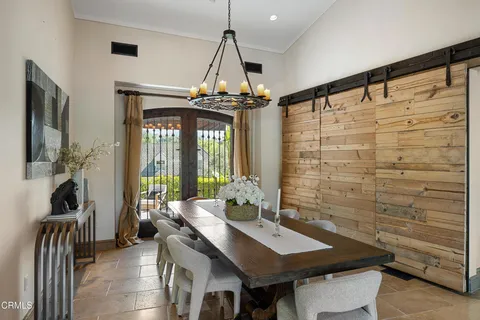 a living room with stainless steel appliances kitchen island granite countertop a table chairs and a wooden floor