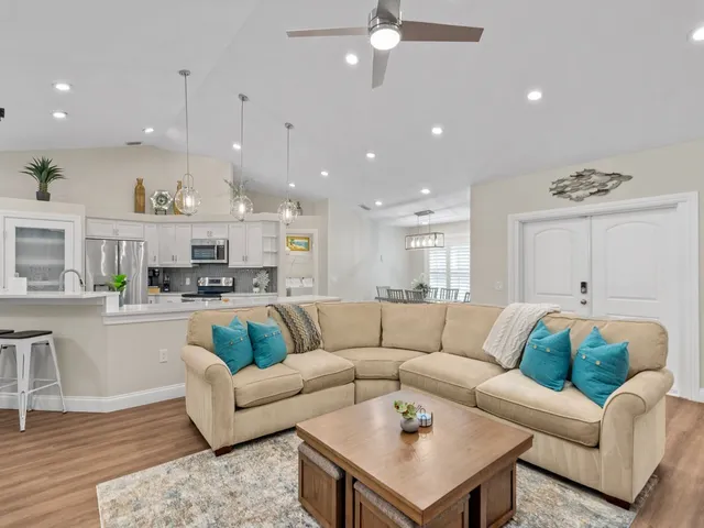 a living room with furniture and a view of kitchen