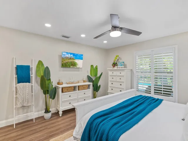a bedroom with a bed a chandelier and a dresser