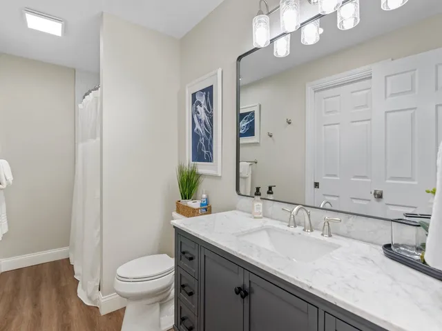 a bathroom with a granite countertop sink a toilet and a mirror