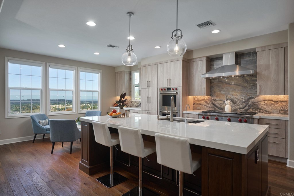3566 Calle Palmito Carlsbad, CA 92009 - Photo 6 of 40 a kitchen with a dining table chairs and wooden floor