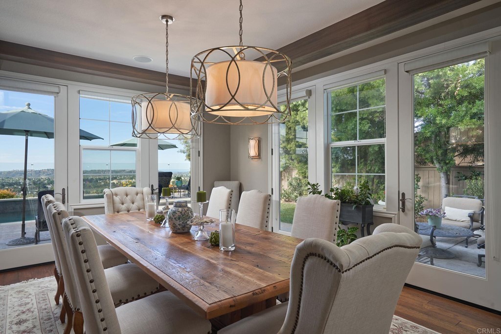 3566 Calle Palmito Carlsbad, CA 92009 - Photo 10 of 40 a dining room with furniture a chandelier and wooden floor