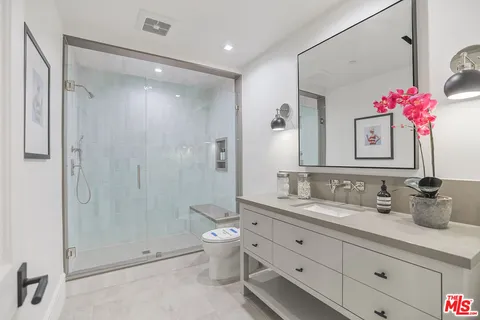 a bathroom with a double vanity sink mirror and shower