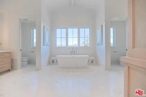 a spacious en suite bathroom with a tub shower and window