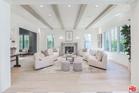 a living room with fireplace furniture and a large window