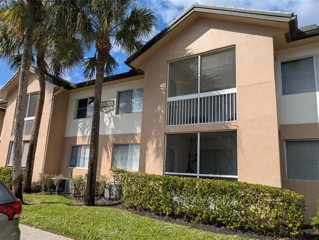 a view of a house with a yard and potted plants