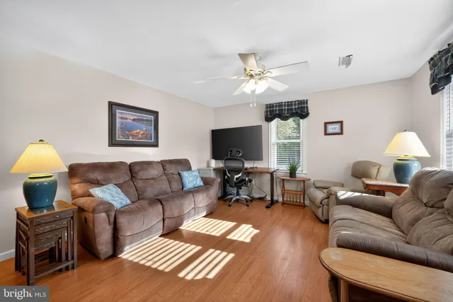 a living room with furniture a wooden floor and a flat screen tv