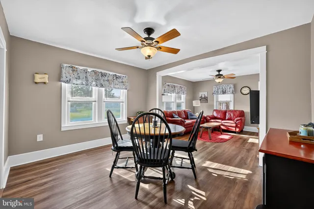 a dining room with furniture a chandelier and wooden floor