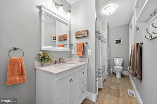 a bathroom with a granite countertop sink a toilet and a mirror