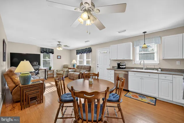 a dining room with furniture a chandelier and wooden floor