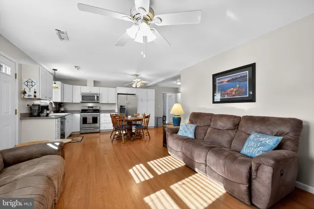 a living room with furniture kitchen view and a chandelier