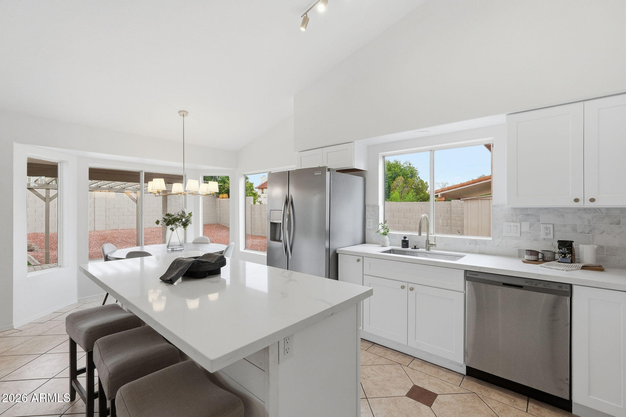 7756 West Hearn Road Peoria, AZ 85381 - Photo 12 of 41 a kitchen with a sink a stove and chairs